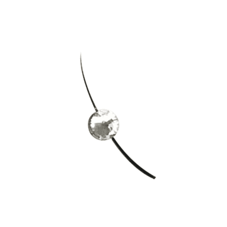 Close-up of a black curved eyelash extension decorated with a clear faceted rhinestone for a sparkling jewel lash effect.