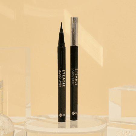 BL Lashes Eyeable Liquid Liner in black with a fine precision tip and silver cap, displayed on a clear acrylic stand.