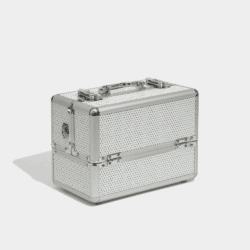 Silver professional beauty case with a textured studded finish, reinforced metal corners, chrome hardware, and a carry handle on a light background.
