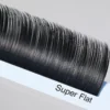 Close-up of black Super Flat eyelash extensions arranged on a white lash tray.