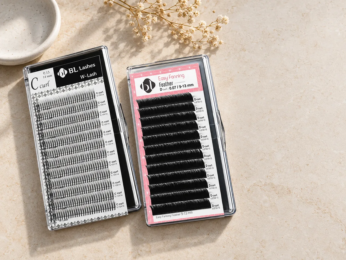 BL W-Lash und Easy Fanning Feather Lashes auf heller Steinfläche mit weisser Keramikschale und Trockenblumen.